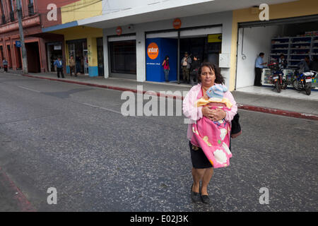 Guatemala City, Guatemala. 15th Mar, 2013. A woman crosses a street with a baby. © Alena Kuzub/ZUMA Wire/ZUMAPRESS.com/Alamy Live News Stock Photo