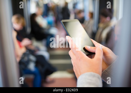 Female mobile phone hand underground message sms e-mail Stock Photo