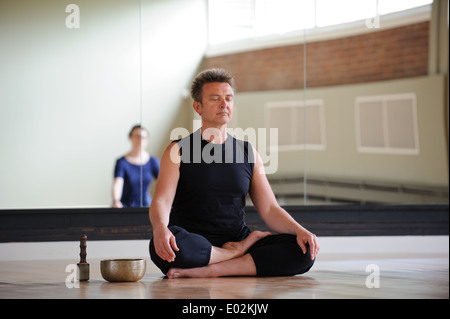 A yoga teacher and class meditating at a Birmingham arts centre Stock Photo