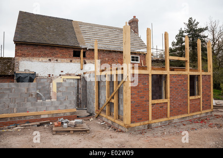 A timber framed extension to an existing brick built house or cottage under construction or being built, England, UK Stock Photo