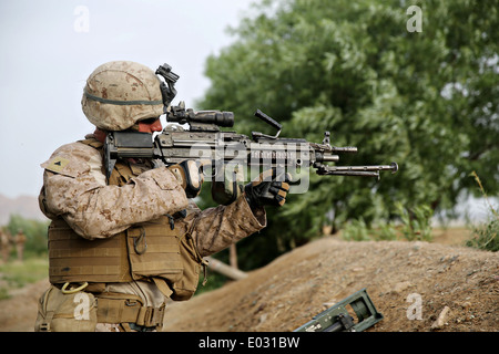 US Marine Lance Cpl. Jonathan Griffiths keeps watch with a M249 Squad Automatic Weapon during a clearing operation mission April 25, 2014 in Larr Village, Helmand province, Afghanistan. Stock Photo