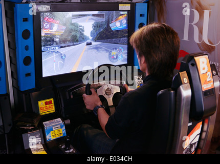 Person playing racing video game slot machines at an arcade in Tokyo, Japan Stock Photo