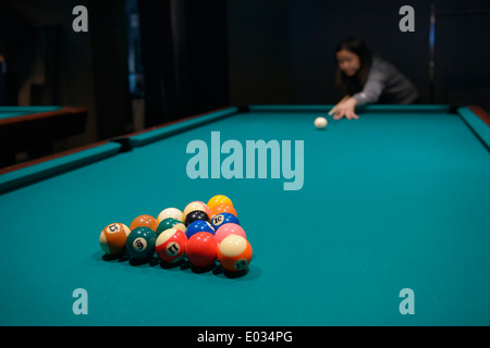 Young woman playing billiards Stock Photo