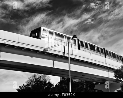 New Transit Yurikamome fully automated train going through Odaiba on elevated overhead railway in Tokyo, Japan. black and white Stock Photo