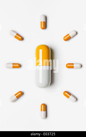 Large pill surrounded by small pills Stock Photo