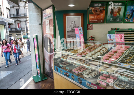 Krispy Kreme doughnut display in shop open to pedestrian Calle Madero to lure passers by walking in Centro Historico Mexico City