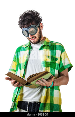 a guy wearing casual clothes and on old pair of goggles over a white background and reading an old book Stock Photo