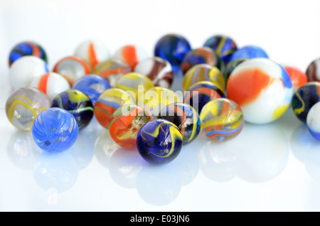 A handful of colorful glass marbles on a white background. Stock Photo