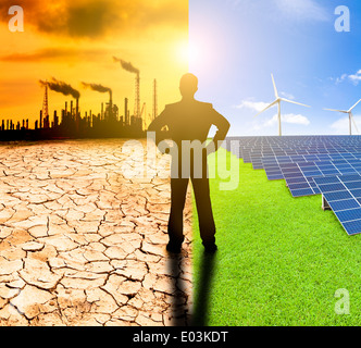 pollution and clean energy concept. businessman watching windmills solar panels and refinery with air pollution Stock Photo