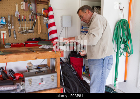 US Speaker of the House John Boehner sharpens his lawn mower blade on his workbench at his home March 25, 2012 in Wetherington, Ohio. Stock Photo