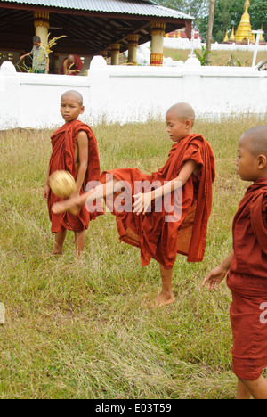 Burmese novices playing Sepak Takraw in front of a temple. Stock Photo