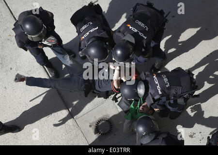 Madrid, Spain. 30th Apr, 2014. Riot police clears the entrace of the building where members of the Victims' Mortgage Platform (PAH) block the door of Veronica Carro, 51, to prevent her eviction, in Parla, Spain, Wednesday, April 30, 2014. Veronica, a former gardener and concierge at Parla's townhall, has resided in the apartment with her 14 year old daughter Rocio for the past 5 years, but since being unemployed for the last 3 years and her only income was a state handout of 426 euros ($584) a month she could not afford to pay a protected rent of 370 euros a month ($513) to Lazora, a privat Stock Photo