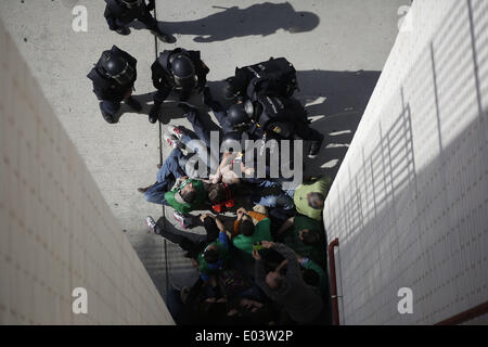 Madrid, Spain. 30th Apr, 2014. Riot police clears the entrace of the building where members of the Victims' Mortgage Platform (PAH) block the door of Veronica Carro, 51, to prevent her eviction, in Parla, Spain, Wednesday, April 30, 2014. Veronica, a former gardener and concierge at Parla's townhall, has resided in the apartment with her 14 year old daughter Rocio for the past 5 years, but since being unemployed for the last 3 years and her only income was a state handout of 426 euros ($584) a month she could not afford to pay a protected rent of 370 euros a month ($513) to Lazora, a privat Stock Photo