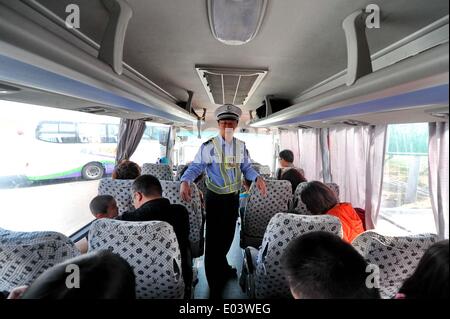 Changchun, China's Jilin Province. 1st May, 2014. Yu Weiqun, a traffic policeman, reminds passengers to fasten their seat belts on a bus in Changchun, capital of northeast China's Jilin Province, May 1, 2014. © Zhang Nan/Xinhua/Alamy Live News Stock Photo