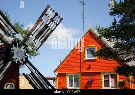 country red wooden house and brown decorative mill wind in summer Stock Photo