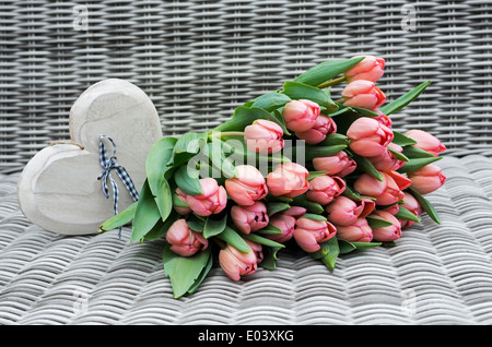 pink tulip flowers and heart shapes for mothers day on bamboo background Stock Photo
