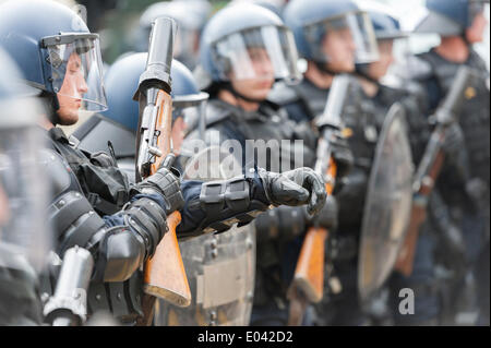 Zurich, Switzerland. 1st May, 2014. A member of the police squad checks on his equipment at an illegal May Day protest rally at Zurich's Helvetiaplatz. The rally disbanded after police squads sealed the place for one hour. Credit:  Erik Tham/Alamy Live News Stock Photo