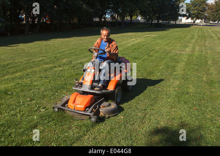 Ride-on lawn mower cutting grass. Stock Photo