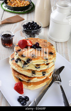 High angle shot of a stack of fresh homemade blueberry pancakes. The plate is on a rustic farmhouse style kitchen table