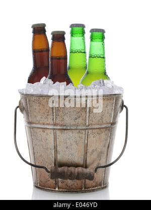 An old fashioned bucket filled with ice and beer bottles. Four brown and green bottles of beer are in vertical format Stock Photo