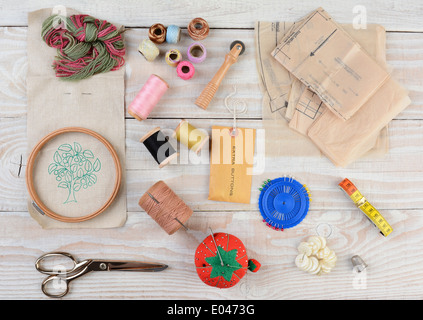 High angle shot of an assortment of sewing and embroidery tools on a rustic wooden background. Stock Photo