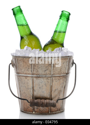 An old fashioned bucket filled with ice and beer bottles. Two green bottles of beer with caps removed Stock Photo