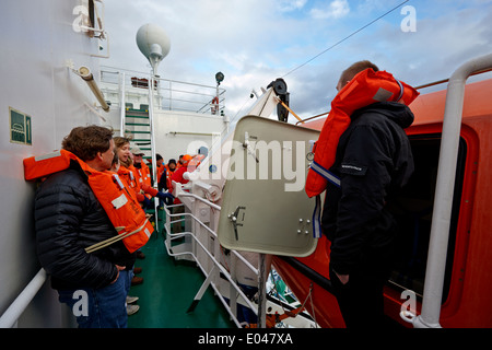 passengers taking part in a lifeboat drill on board ship Stock Photo