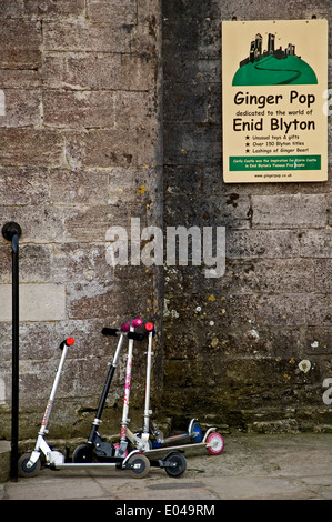 Childrens scooters lined up outside a shop advertising Enid Blyton, childrens author. Stock Photo