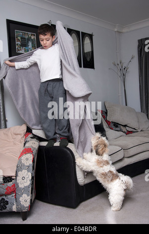 little boy playing in house with shih tsu puppy Stock Photo