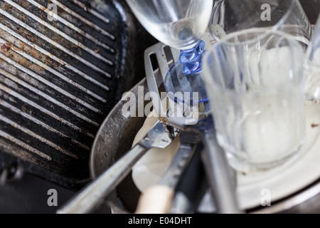 a lot of dirty pans, glasses and other kitchen utensils in a sink Stock Photo