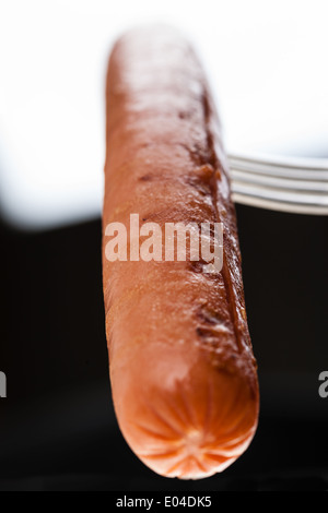a delicious sausage on a fork over white Stock Photo