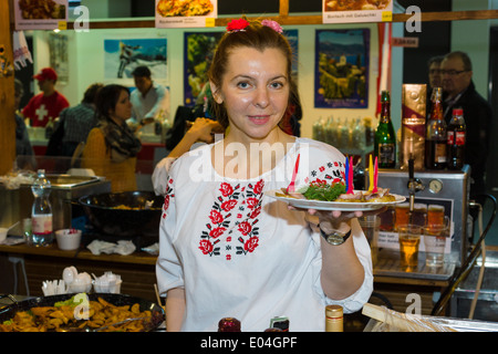 Green Week 2012. Berlin. Germany. Woman in traditional Ukrainian clothes serves food. Stock Photo