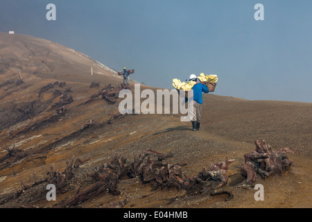 Men with baskets used for transportation of sulfur blocks, rim of Kawah Ijen, Banyuwangi Regency, East Java, Indonesia Stock Photo