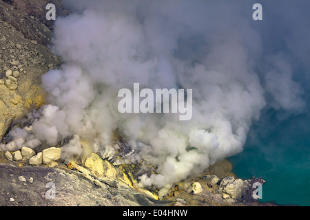 Sulfur mine near turquoise acid crater lake, Kawah Ijen, Banyuwangi Regency, East Java, Indonesia Stock Photo