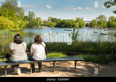 Two young women enjoying the summer view of the Boating Lake in Regents Park, London,England UK Stock Photo