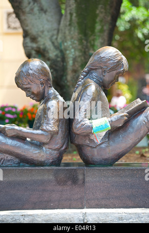 Reading in the Sun, Metal Statues Of Children Reading Outside The Library, Causeway Bay, Hong Kong. Stock Photo