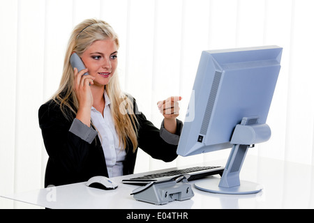 Young woman with a telephones call in the office., Junge Frau bei einem Telefonat im Buero. Stock Photo