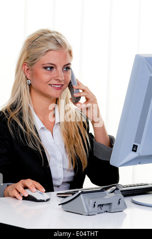 Young woman with a telephones call in the office., Junge Frau bei einem Telefonat im Buero. Stock Photo