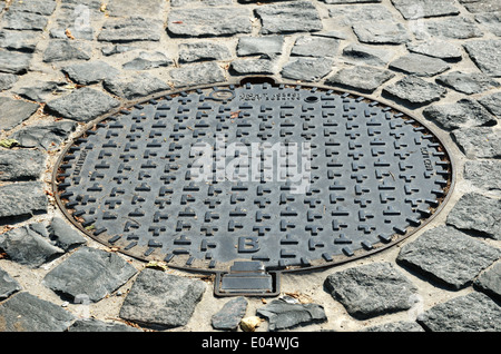 Sewer manhole on the stone pavement Stock Photo