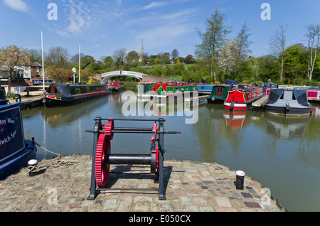 Braunston Marina, UK; old winching gear in the foreground, moored narrow boats in the background Stock Photo