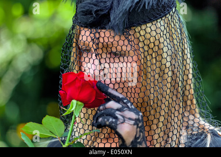 A young, mourning widow with veil and rose. Death and inheritance., Eine junge, trauernde Witwe mit Schleier und Rose. Todesfall Stock Photo