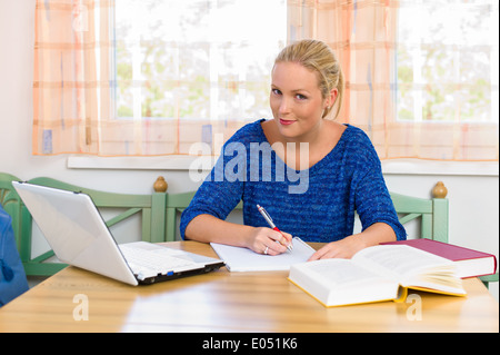 A young student with learn for her study in her flat., Eine junge Studentin beim lernen fuer ihr Studium in ihrer Wohnung.