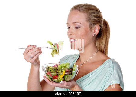 A young woman eats a crisp salad in the lunchbreak. Healthy food with vitamins., Eine junge Frau isst einen knackigen Salat in d Stock Photo