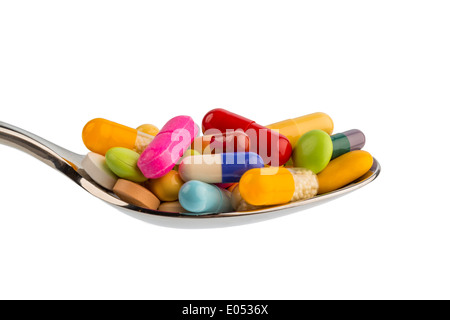 Many coloured tablets on a spoon. Symbolic photo for tablet addiction and abuse of drugs.