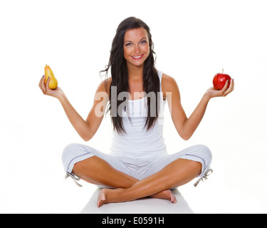 A young woman holds an apple and a pear in the hand. Fit by healthy food, Eine junge Frau haelt einen Apfel und eine Birne in de Stock Photo