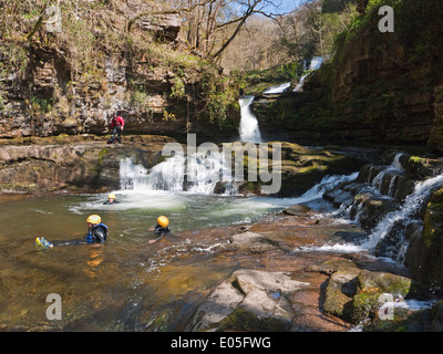 Canyoners in Sgwd Isaf Clun-gwyn falls on the Afon Mellte, in Brecon Beacons National Park waterfalls country Stock Photo