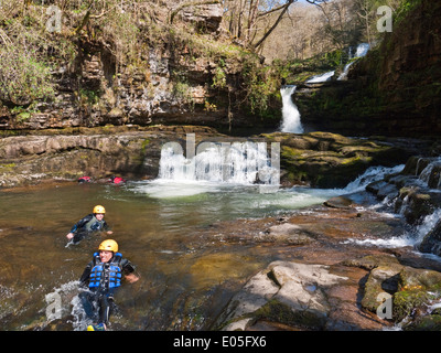 Canyoners in Sgwd Isaf Clun-gwyn falls on the Afon Mellte, in Brecon Beacons National Park waterfalls country Stock Photo