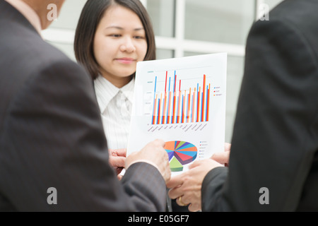 Asian business team meeting. Staff presenting chart to CEO boss over office. Stock Photo