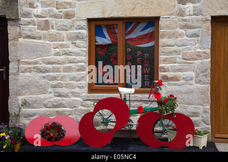 Scorton, Lancashire 3rd May. 2014.  'Poppy Pedal Power' at the Bank Holiday Bikes & Barrows Festival.  May Day Bank Holiday weekend of decorated bikes and barrows in the picturesque village of Scorton, near Lancaster.  Thousands of people are expected to visit Scorton to join in events and see lots of decorated bicycles and wheelbarrows throughout the village. Last year there were nearly a hundred on display with the raising vital funds for projects that will maintain the fabric of village life and preserve its identity and charm. Credit:  Mar Photographics/Alamy Live News Stock Photo