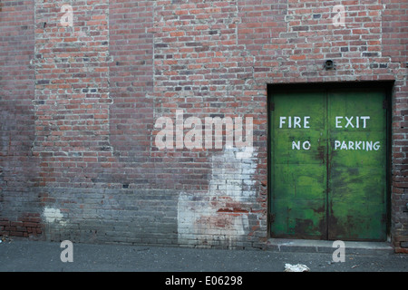 Fire exit, no parking doorway in a brick building to an alley Stock Photo